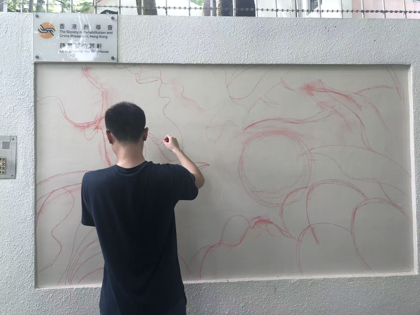 A participant drawing the mural composition on the wall